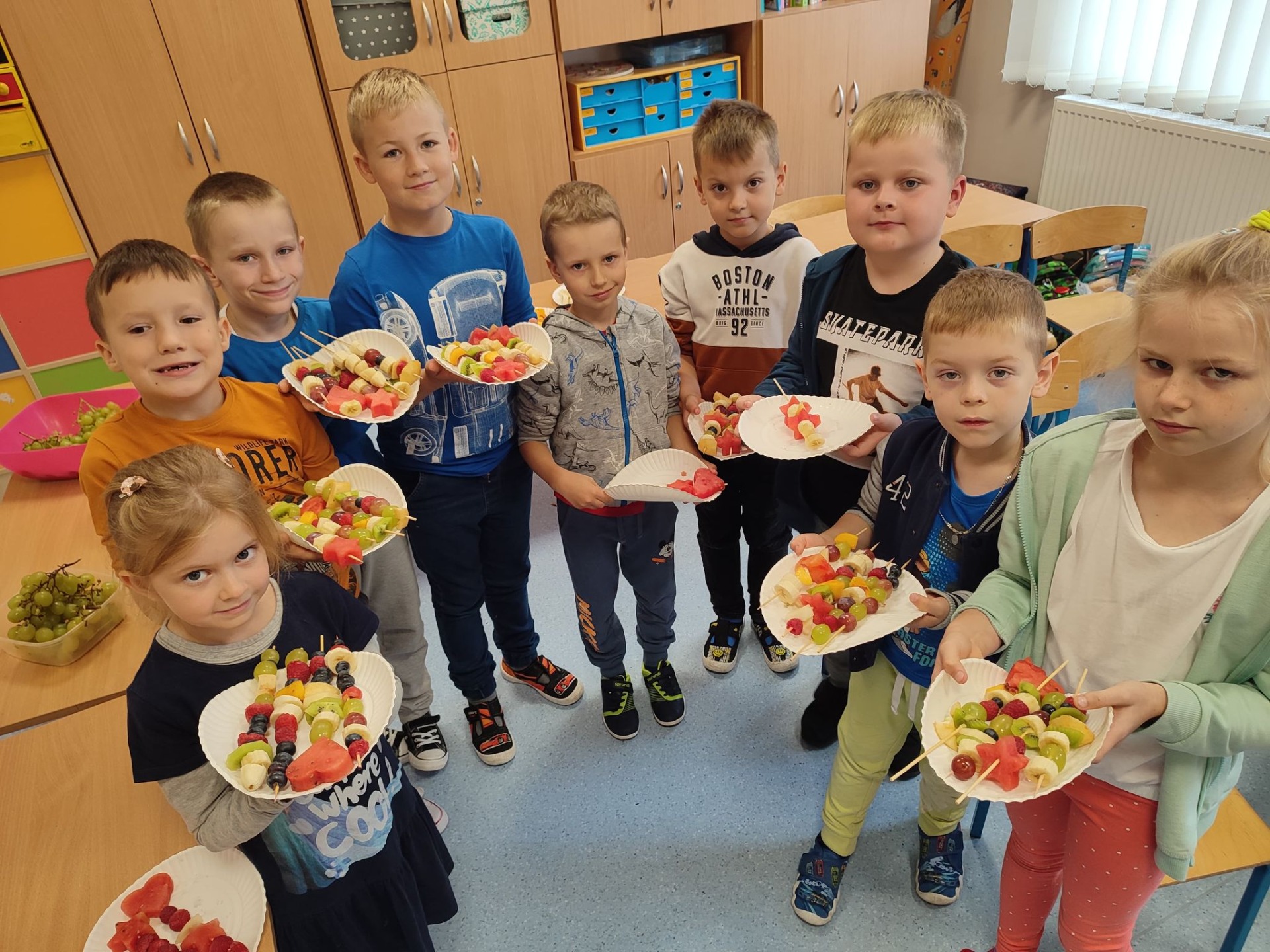 Uczniowie prezentują szaszłyki owocowe.