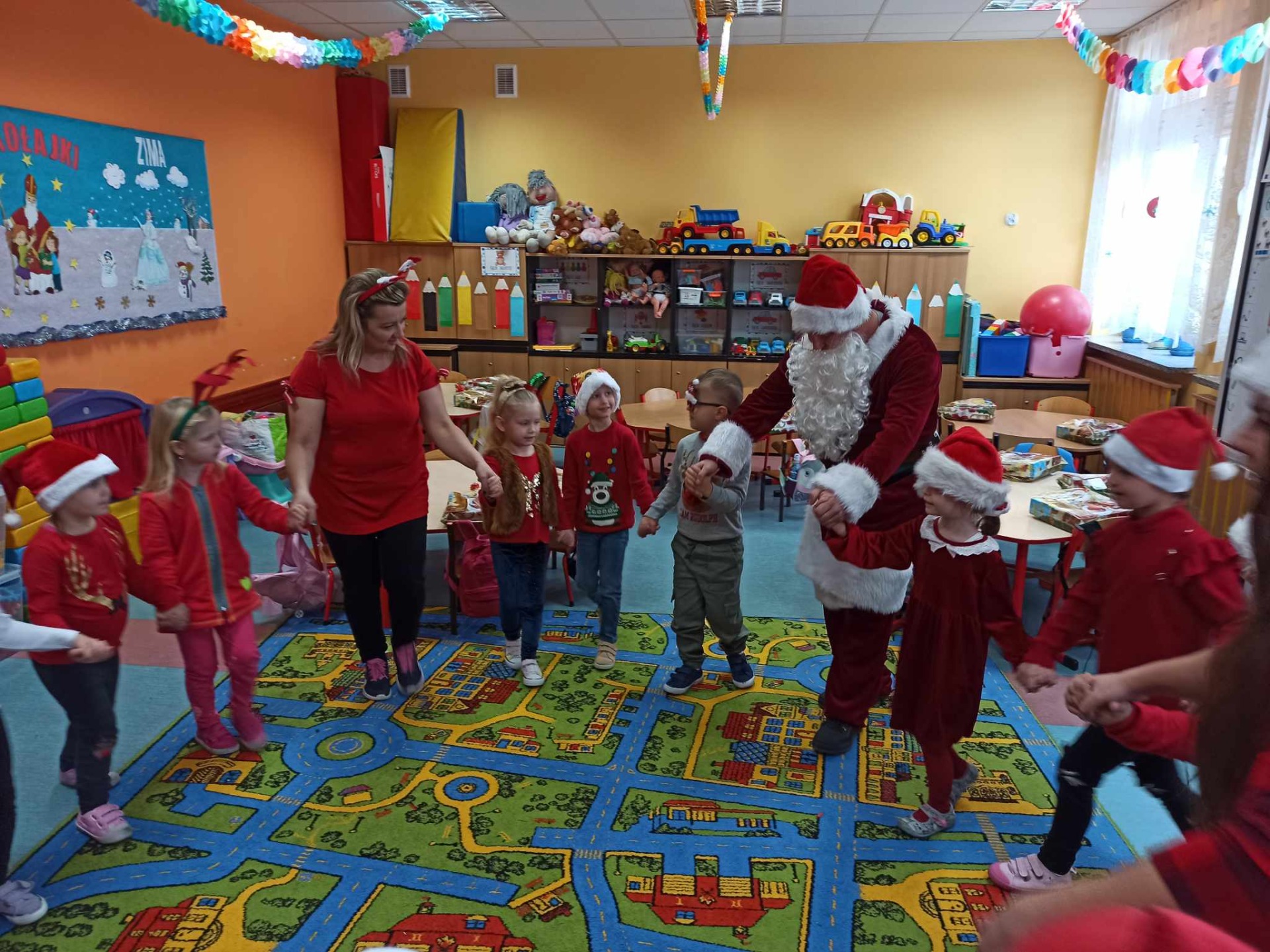 Przedszkolaki bawią się z Mikołajem w sali lekcyjnej