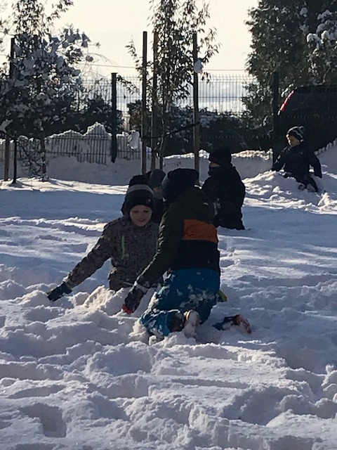 Dzieci toczą kolejne śnieżne kule