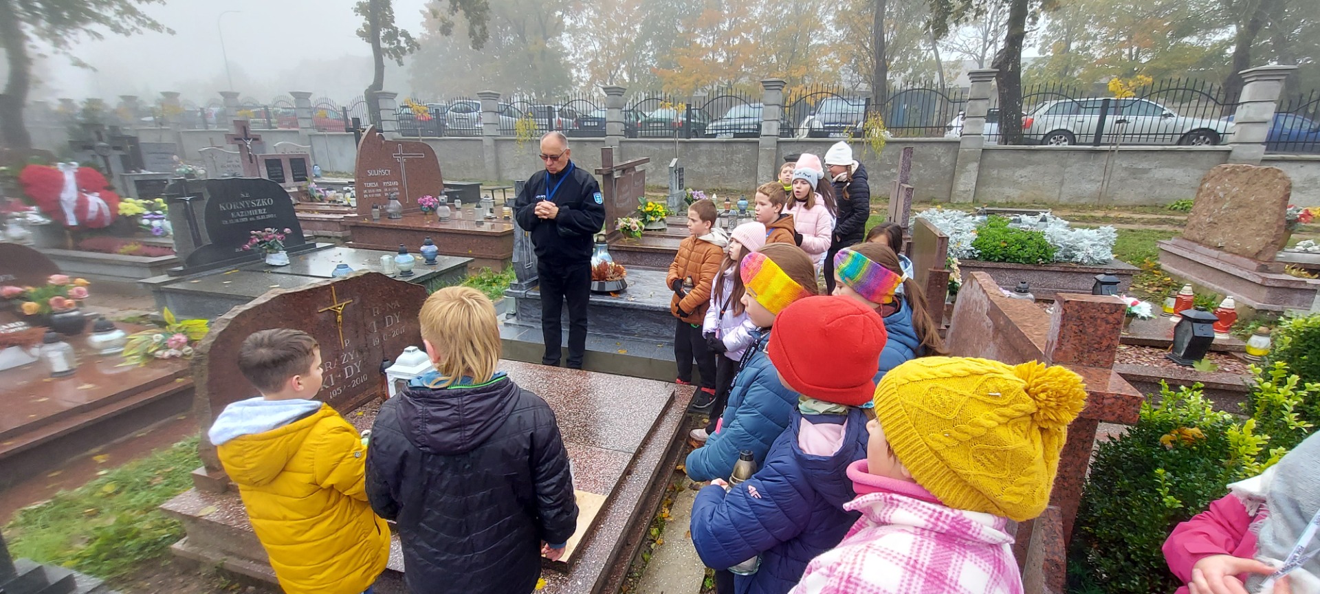 Akcja "Dzieli nas tylko czas..." opiekunowie z uczniami Szkoły Podstawowej Nr 2 im. M. Kopernika w Olecku podczas wizyty przy grobach i modlitwie