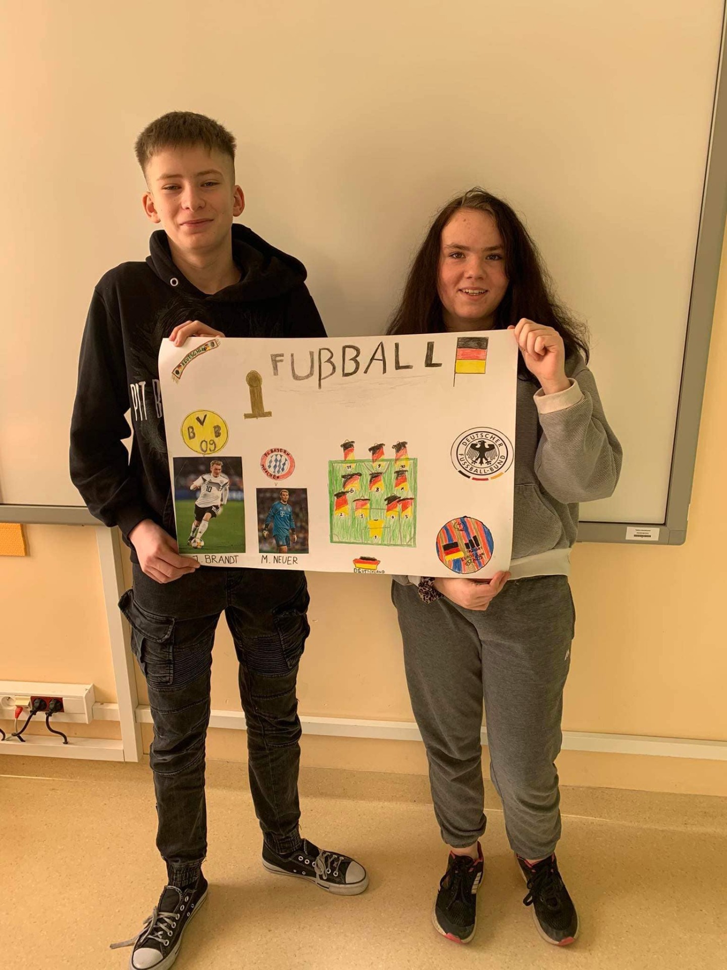 Kamil i Amelka  wraz z wykonanym przez siebie plakatem dotyczącym niemieckiej piłki nożnej.