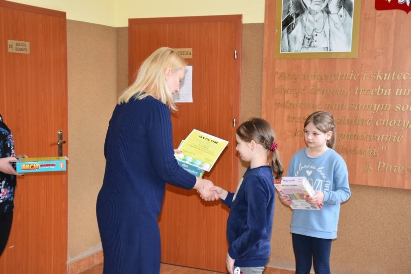 Wicedyrektor szkoły wręcza nagrody zwycięzcom konkursu świetlicowego