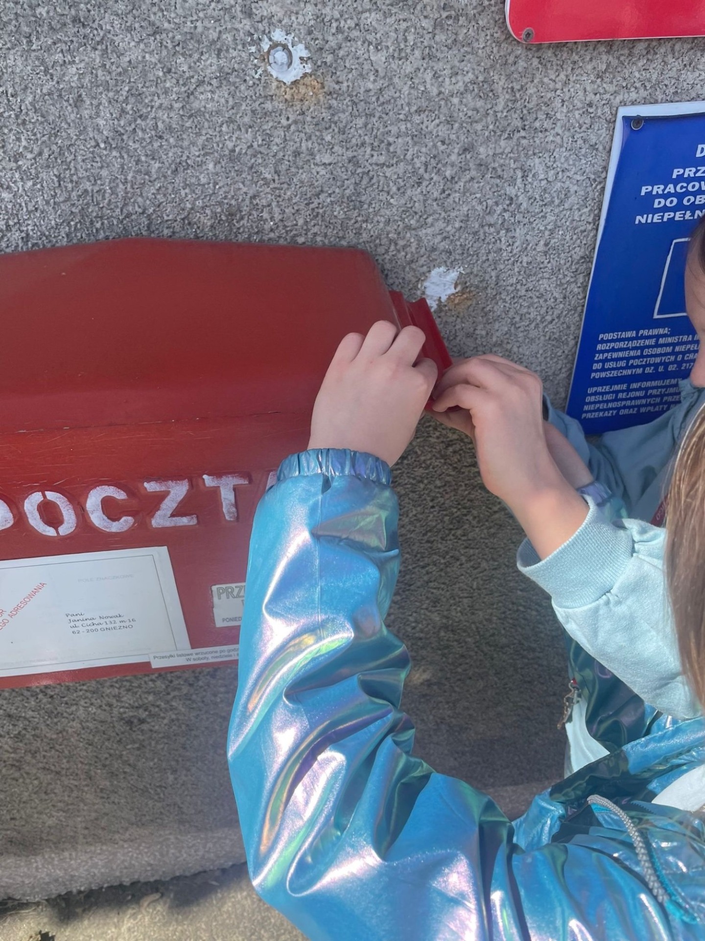 Dzieci wrzucają kartkę do skrzynki pocztowej 