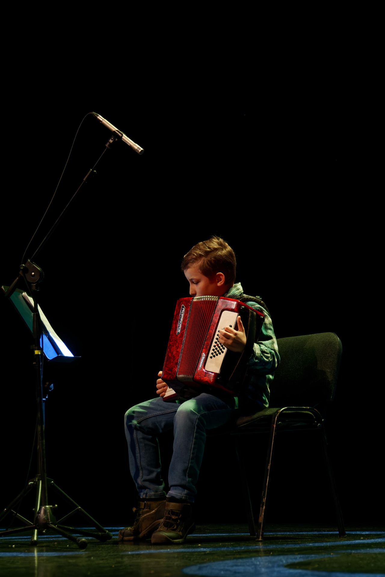 Chłopiec gra na akordeonie  na scenie Pyrzyckiego Domu Kultury podczas 2 Pyrzyckiego Konkursu Talentów.