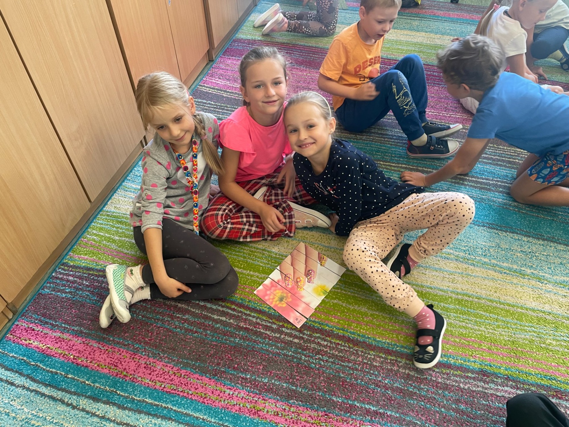dzieci na dywanie układają puzle