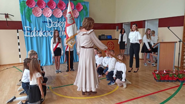  Dyrektor szkoły - pani Anna Sarnowska pasuje uczniów klasy I