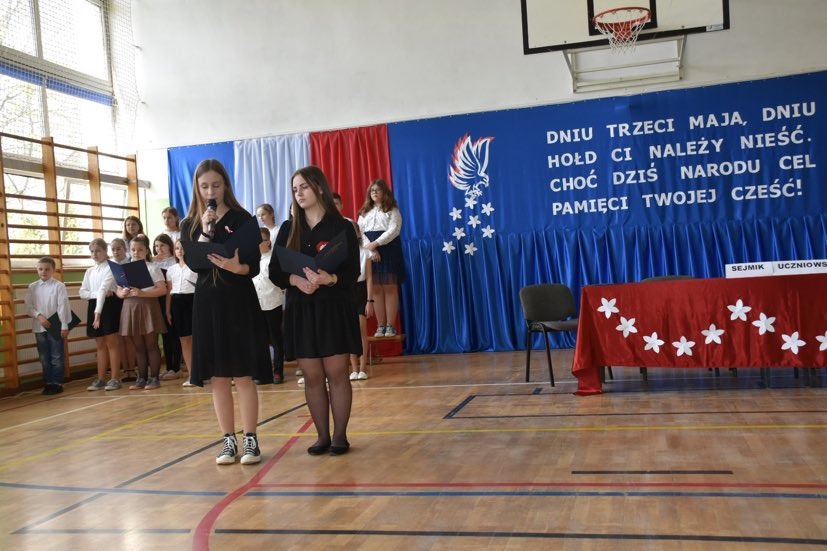 Uczniowie występują w montażu słowno - muzycznym z okazji Święta Konstytucji
