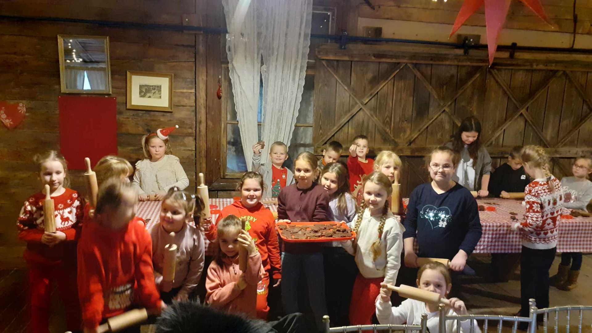 Grupa uczniów pozuje do wspólnego zdjęcia ze Świętym Mikołajem.